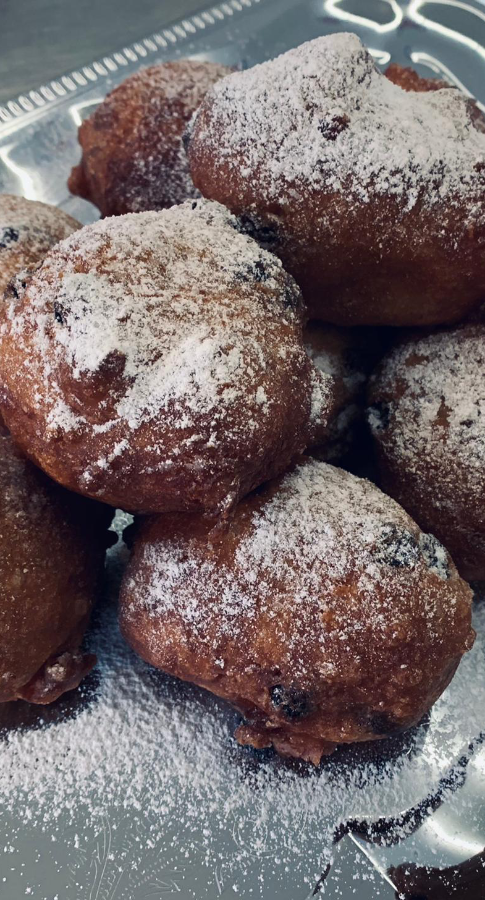 Verse oliebol met rozijnen en poedersuiker